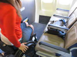 Women in wheelchair trying to transfer to an airplane seat