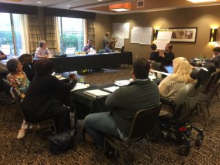 PAC members sitting at tables in a meeting room