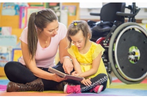 teacher working with student on play floor mat
