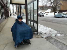 William Crowley awaits bus wearing parka in winter