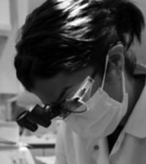 Dentist wearing mask and eye gear, working on a patient
