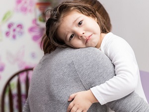 Girl hugging parent with sad eyes